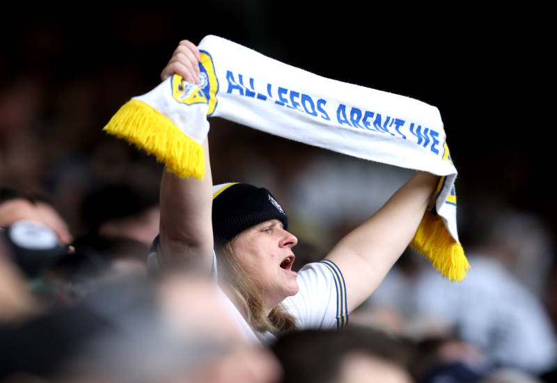 Leeds United fan holds a scarf aloft